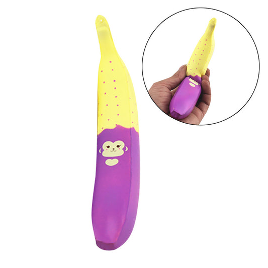 One banana-shaped squishy, yellow top with pink dots and purple base with monkey face and heart, held in hand.
