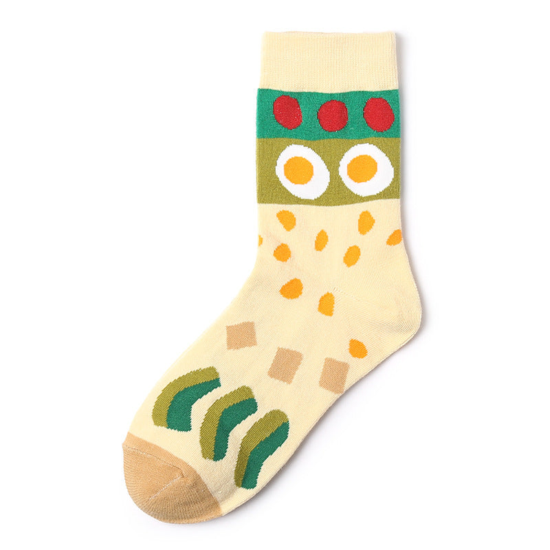 One cream sock with green band of three red dots, two fried-egg motifs, yellow flecks, tan toe.