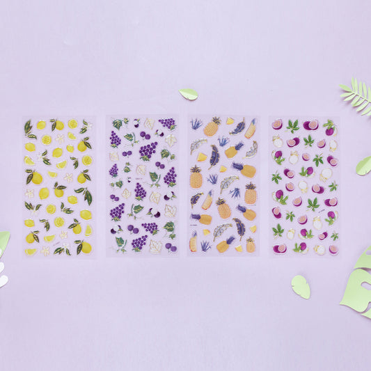 Four metallic fruit sticker sheets, lemon, grape, pineapple and passion fruit, on a lilac background