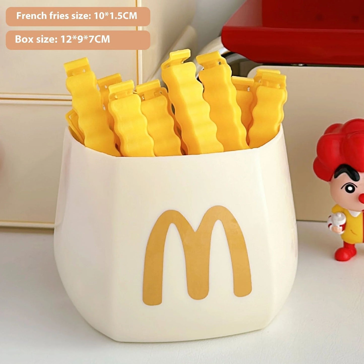 White fries container with gold M logo holding eight yellow wavy bag clips.
