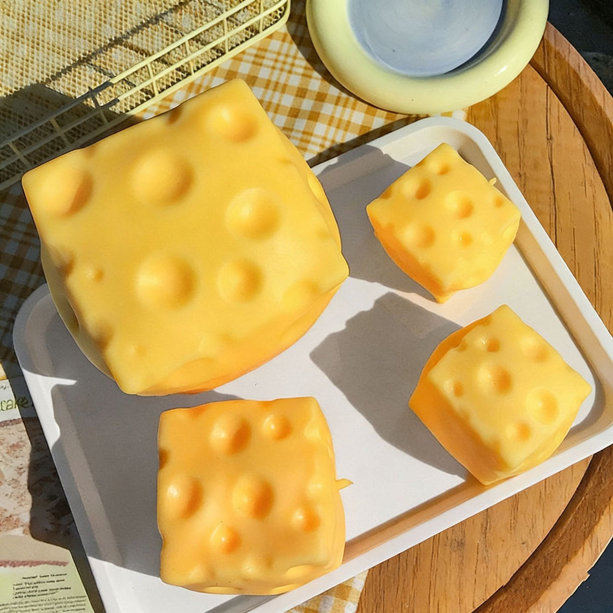 Three sizes of cheese block squishy on a tray