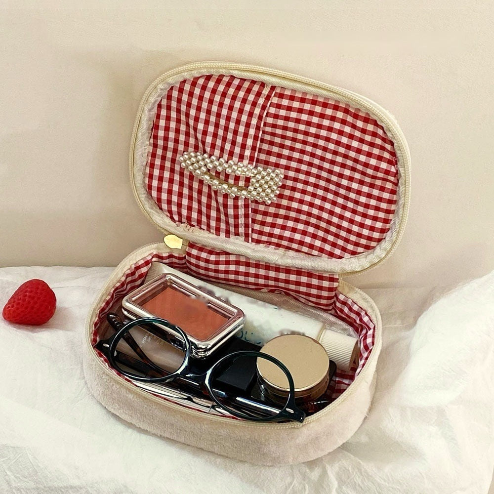 Inside the strawberry sando makeup bag: red gingham lining with a pocket in the lid