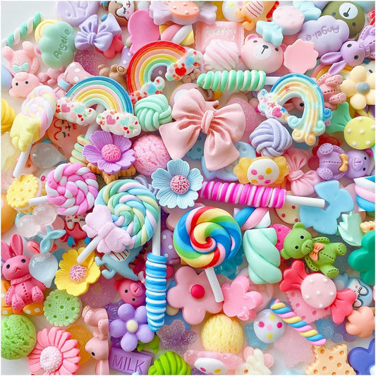 Pile of pastel candy resin phone case charms including rainbows, lollipops, flowers and bows