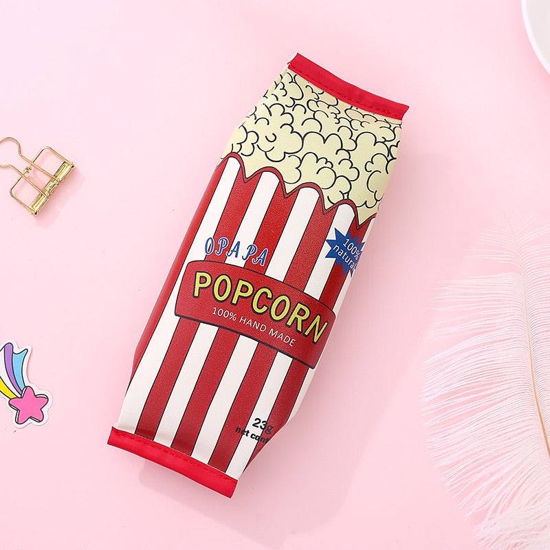 Popcorn snack packet pencil case standing upright beside a gold paper clip