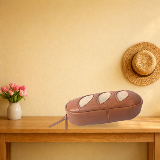 Tan baguette faux leather makeup bag on a light oak console table