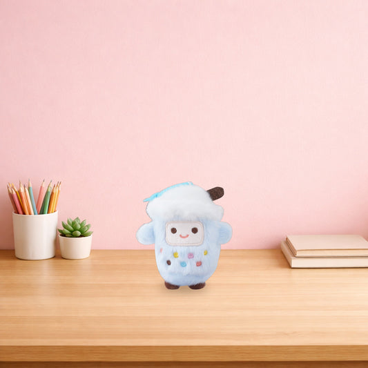 Blueberry bubble tea cup plush keychain on a light oak desk