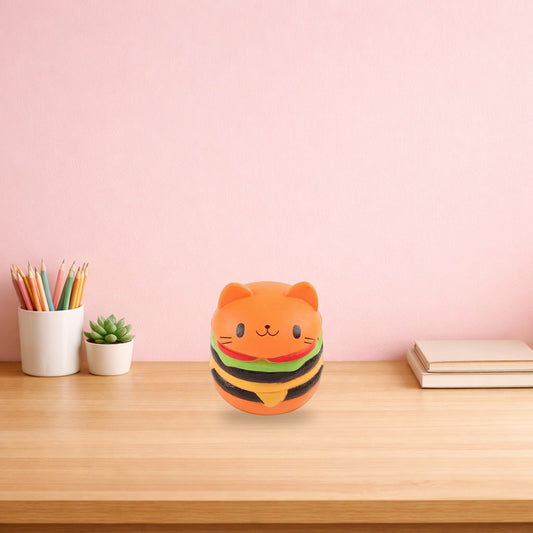 Cat face burger squishy sitting on a light oak desk beside pencils