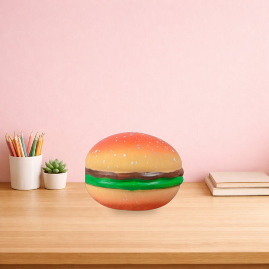 Burger stress ball sitting on a light oak desk beside a pot of pencils