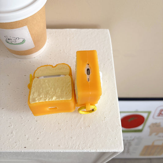 Toast AirPods case open next to a coffee cup