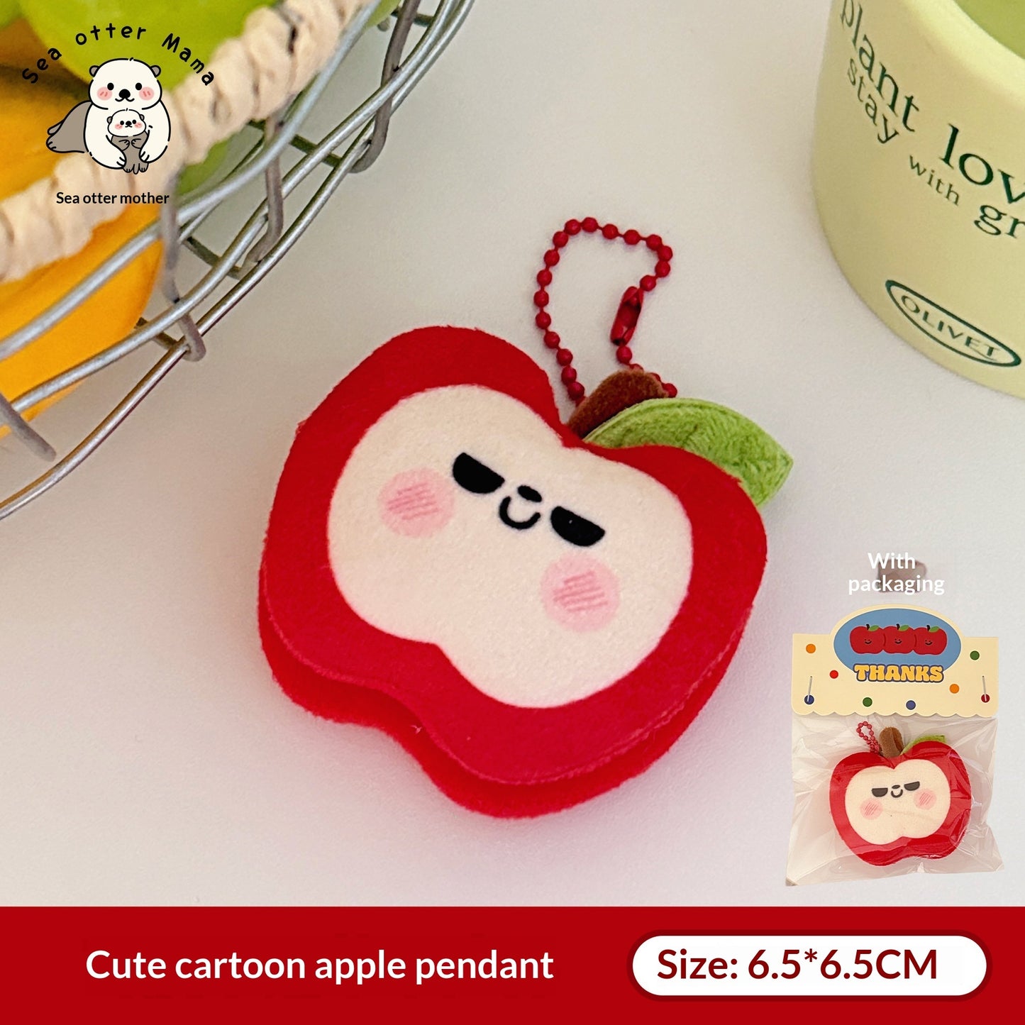 One red plush apple keychain with white face, black sleepy eyes, pink cheeks, green leaf and red bead chain.