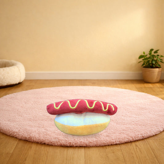 Hot dog squeaky plush dog toy on a pink rug in a living room