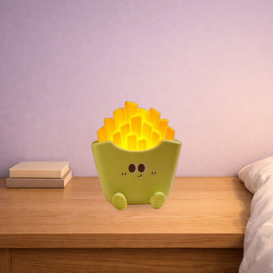 Green fries night lamp glowing warm yellow on a bedside table in the evening