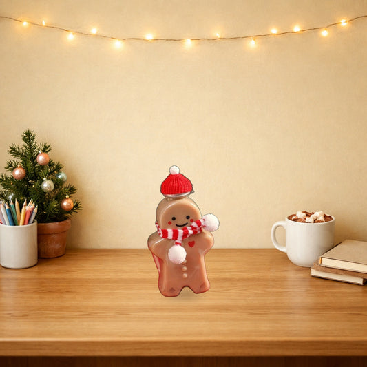 Gingerbread man bottle with a knitted hat and scarf on a Christmas desk