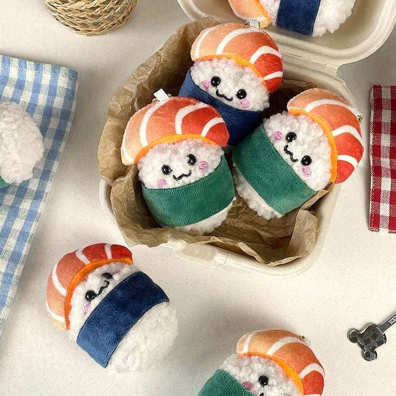A lunch box full of smiley salmon sushi plush charms with green and blue nori bands