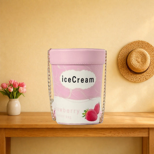 Pink ice cream tub crossbody bag with its chain on an oak hall table