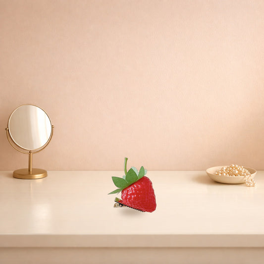 Strawberry resin hair clip on a cream dressing table