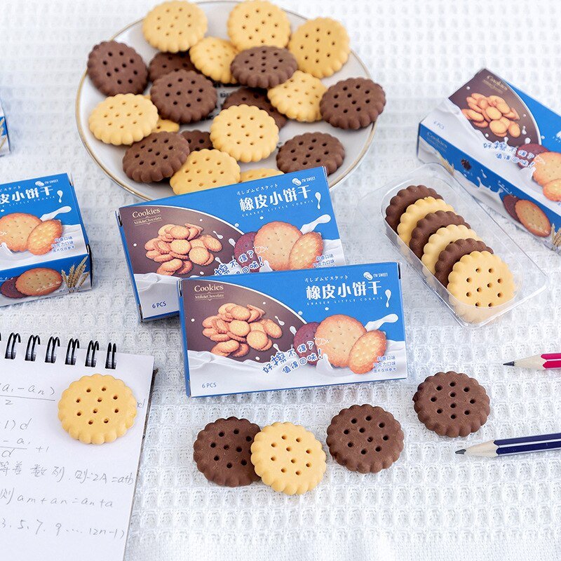 Biscuit erasers and boxes on a desk with a notepad and pencils