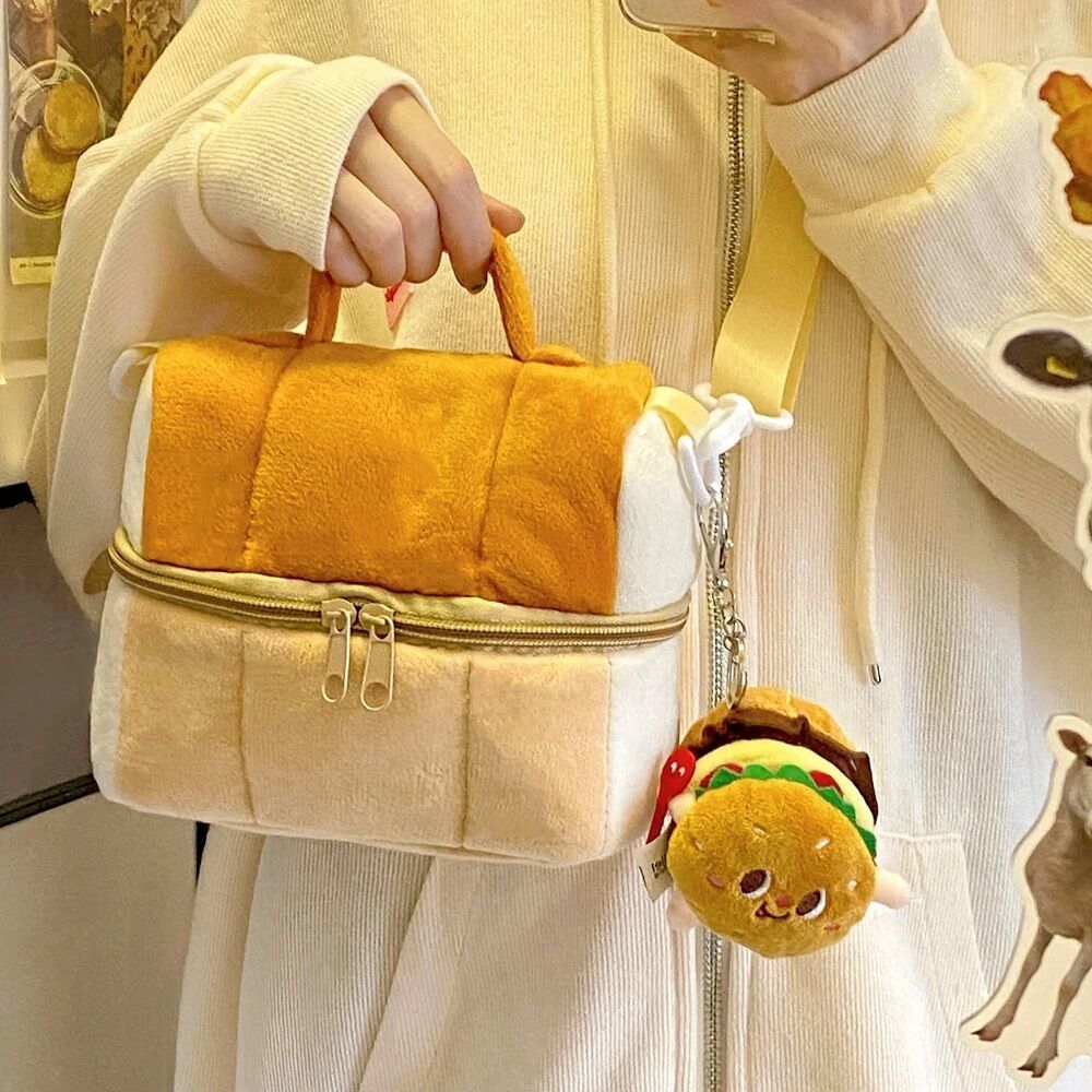 Bread loaf shaped plush zip bag with top handle, carried with a burger keyring charm attached