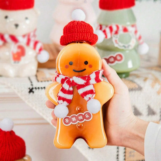 Gingerbread man bottle filled with orange juice, held in hand at a festive table