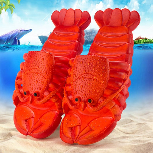 Pair of red lobster slippers on a sandy beach with an underwater sea backdrop