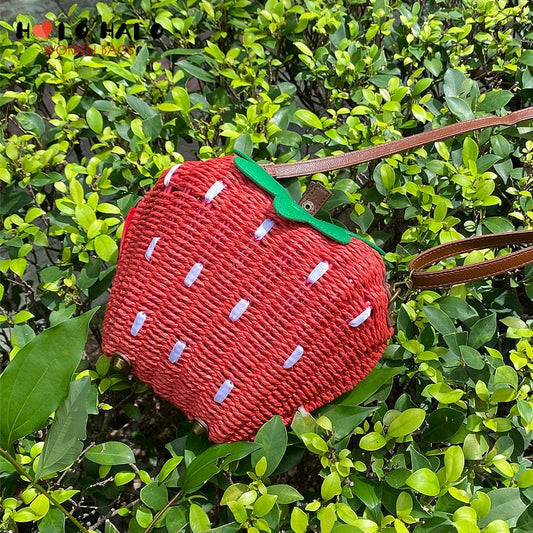 Woven strawberry bag among green leaves