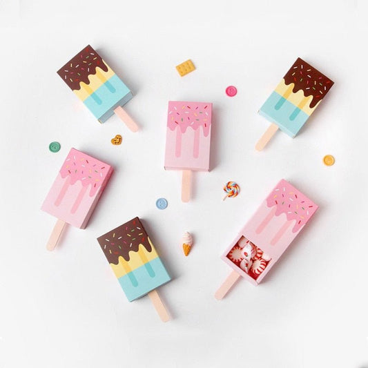 Pink and blue ice lolly shaped party favour boxes scattered with sweets
