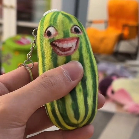 Grinning watermelon plush keychain held in a hand, striped green body