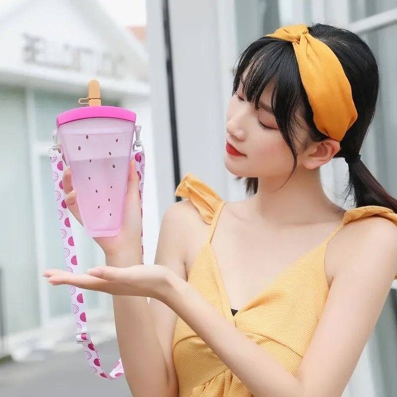 Woman showing the pink ice lolly bottle with its watermelon-print strap