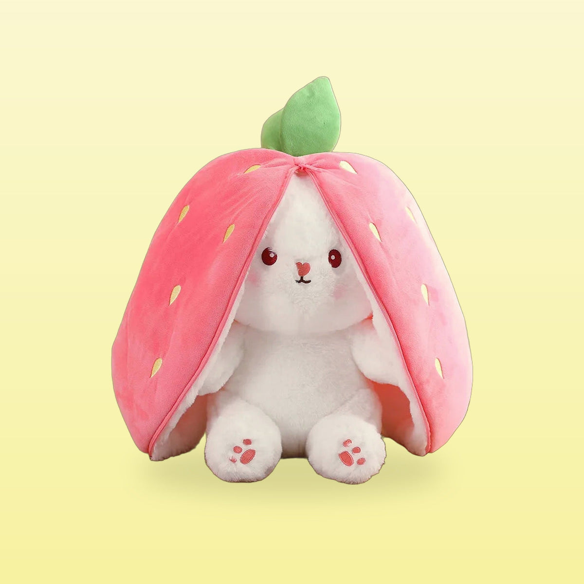 Strawberry rabbit plushie, white bunny peeking out of a pink strawberry hood, on a butter yellow background