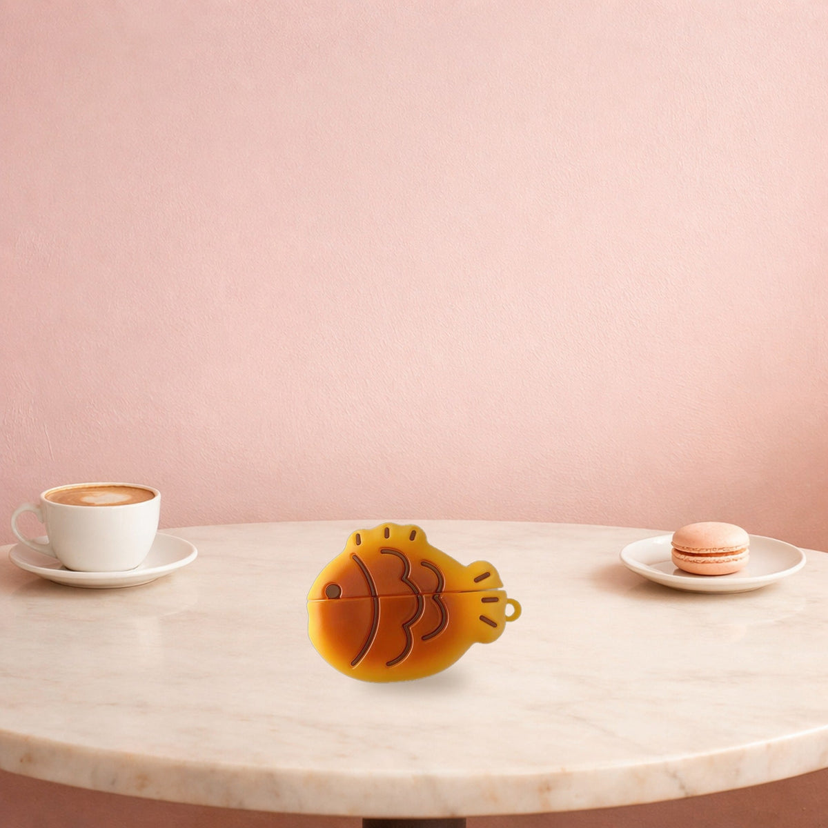 Taiyaki fish AirPods case on a marble café table