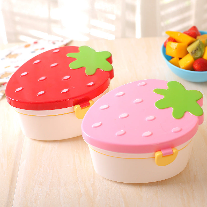 Red and pink strawberry lunch boxes on a table