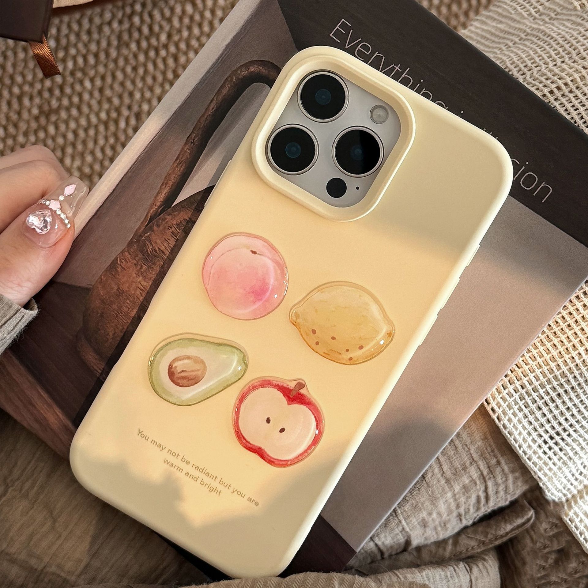 Yellow 3D iPhone case featuring glossy fruit designs: peach, avocado, lemon, and apple, with a motivational quote below.