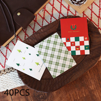 Three festive Christmas biscuit gift bags featuring different designs: trees, plaid, and a patterned check with holiday mo...