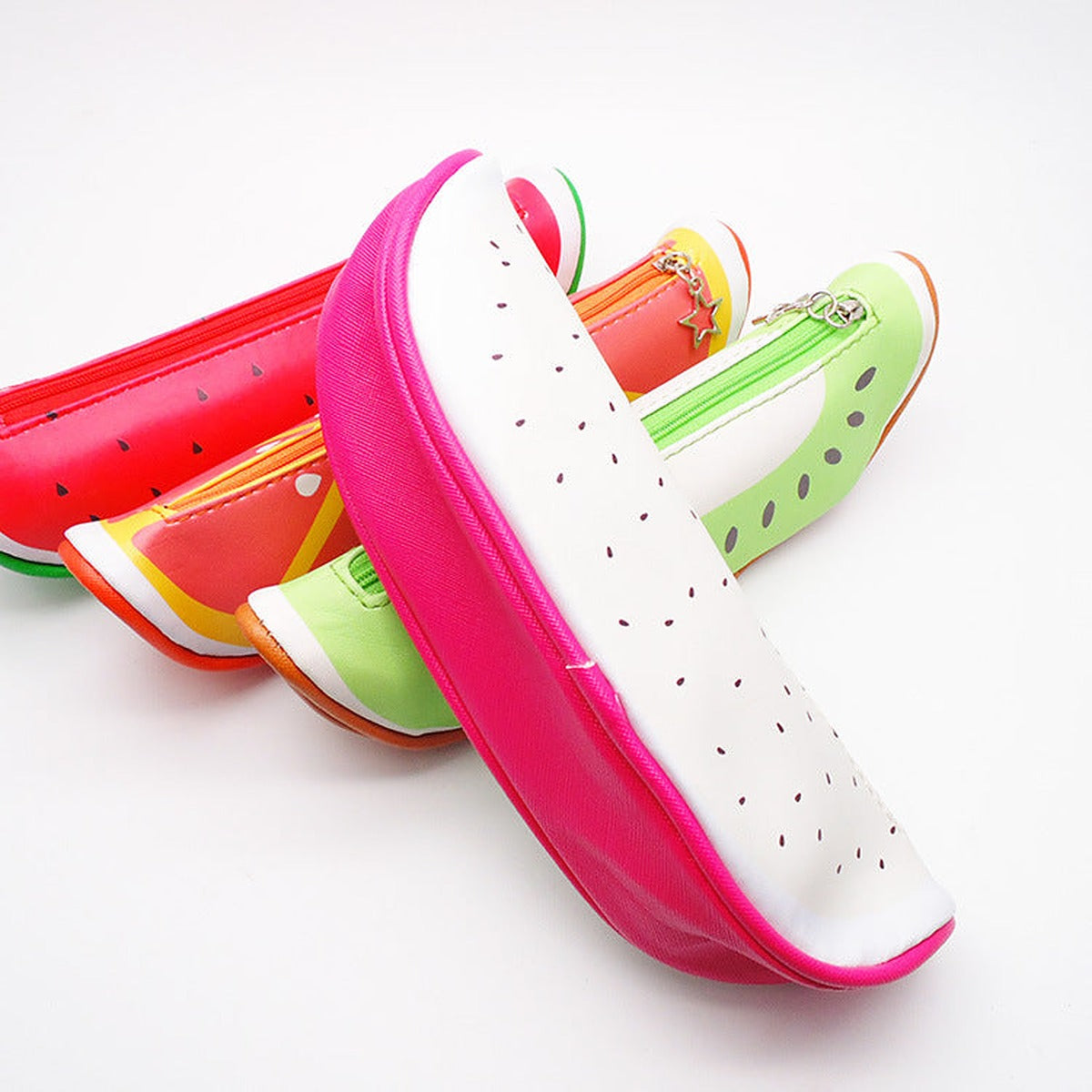 Fruit slice pencil cases stacked with the pink dragon fruit one at the front