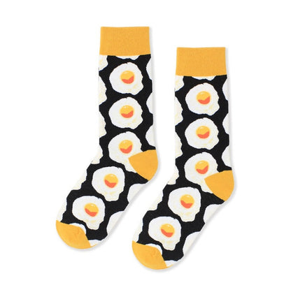 Pair of black crew socks with white fried egg pattern and yellow cuffs, heels and toes