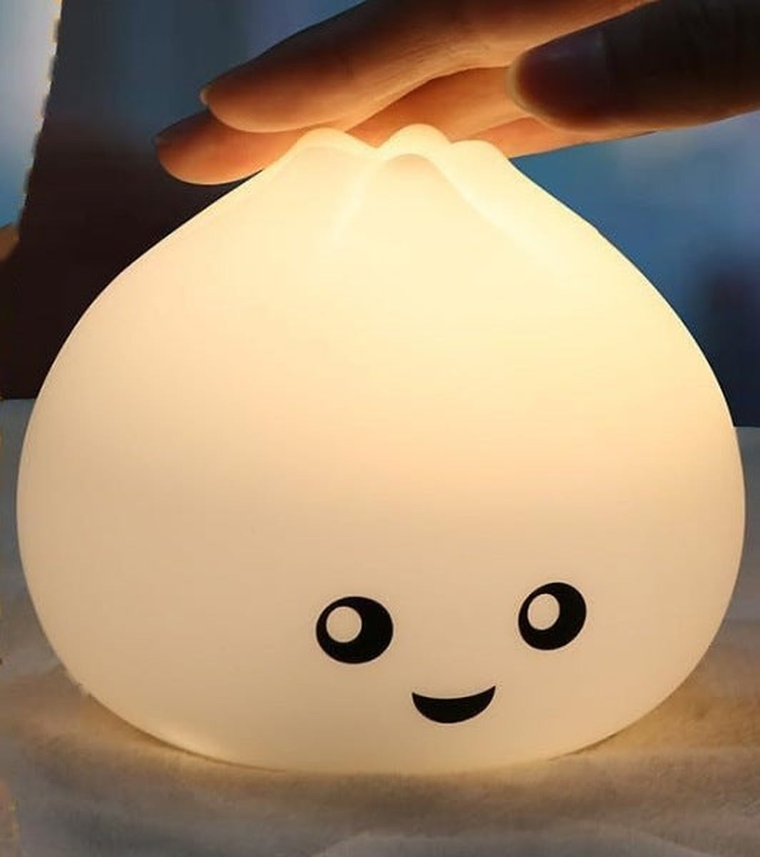 Hand resting on top of the glowing bao bun night light to show its size
