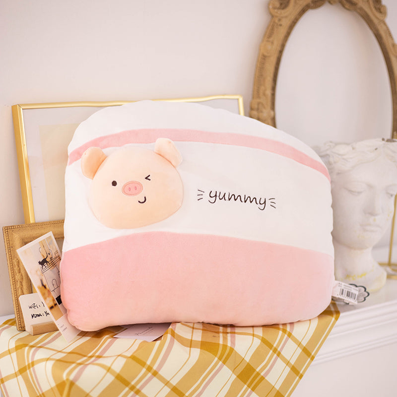 One pink-and-white striped plush cushion with a winking pig face applique and "yummy" embroidery.