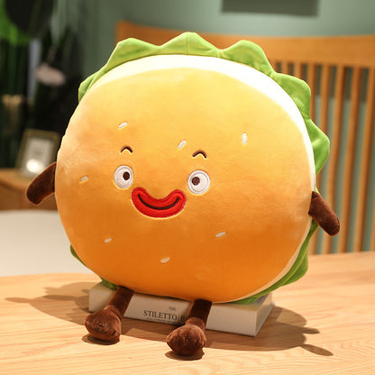 One round orange plush hamburger cushion with green lettuce ruffle, embroidered smile, brown arms and legs.