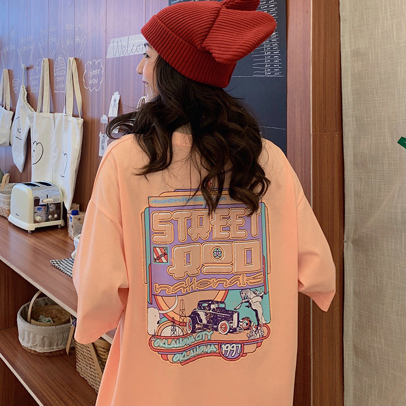 One oversized peach T-shirt with large colorful vintage car 'Street Rod' graphic on back, worn by a model.