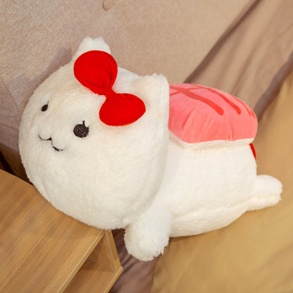 One white fluffy cat plush with red bow and pink striped cushion on its back, lying on a bed by a nightstand.
