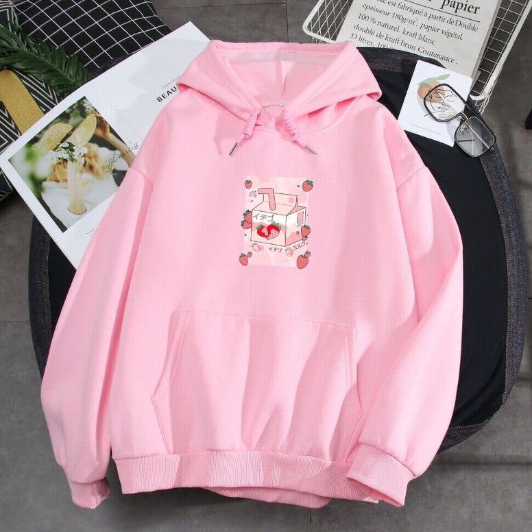 One light pink hoodie with drawstrings, kangaroo pocket and a small strawberry milk carton graphic on chest.
