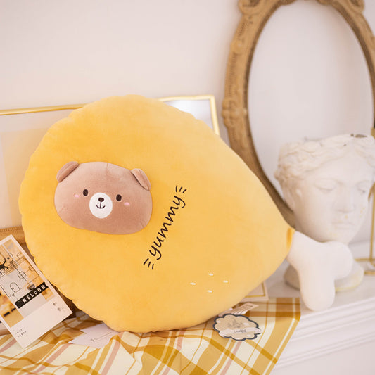 One yellow round plush cushion with brown bear face, 'yummy' embroidery and white bone-shaped foot.