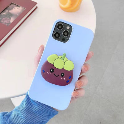 Light blue iPhone case with a 3D smiling purple fruit with green top, shown in one hand.