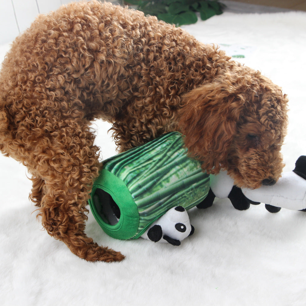A curly-haired dog plays with a green bamboo-shaped snuffle toy, featuring a panda peeking out.