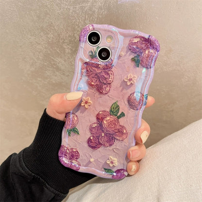 One lavender iPhone case with raised oil-paint purple roses, small cream flowers and wavy edges, held in hand.