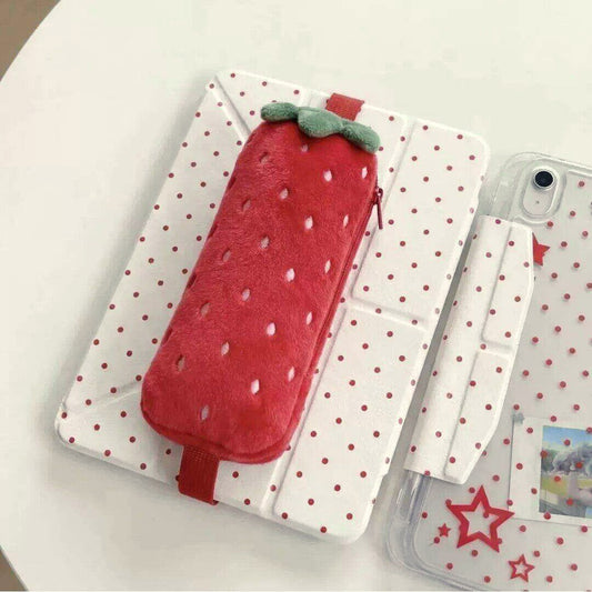 Red strawberry plush pencil case with a green top, strapped to a white polka dot tablet cover