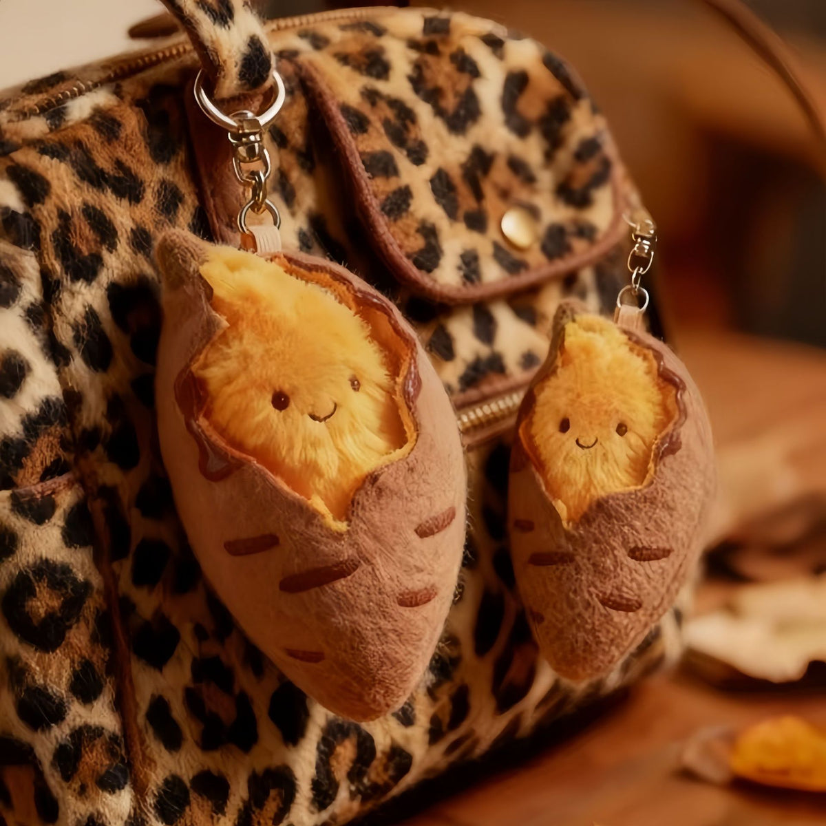 Two sweet potato plush charms on a leopard print bag
