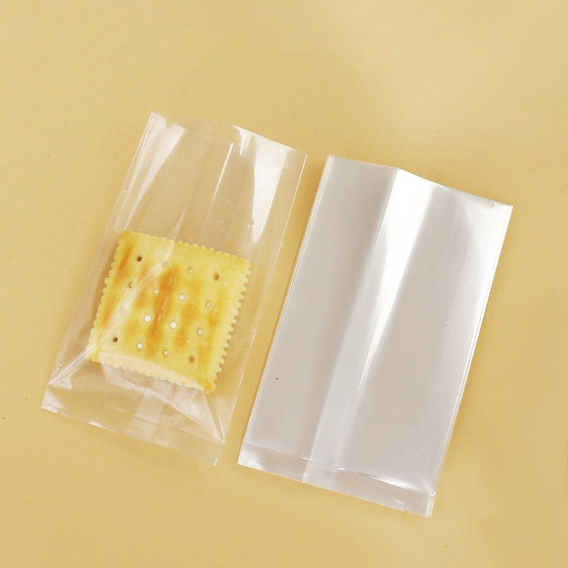 Transparent gift bags containing a golden-brown Christmas biscuit with dotted surface and a plain back.