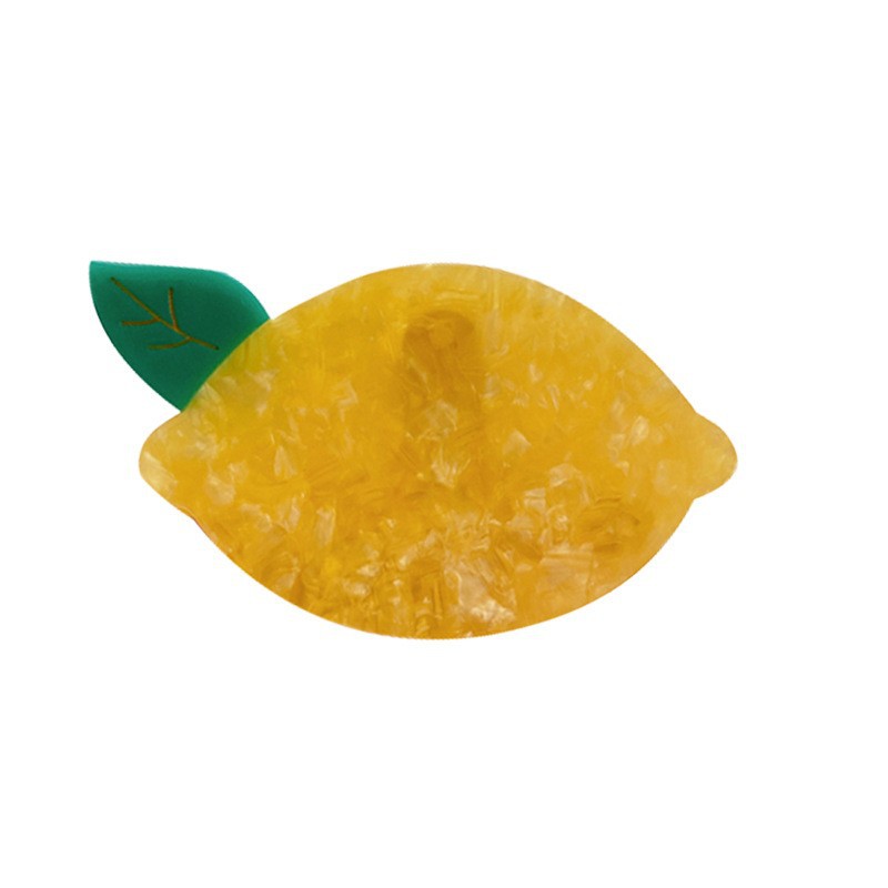One lemon-shaped hair claw clip in marbled yellow resin with a small green leaf on white background.