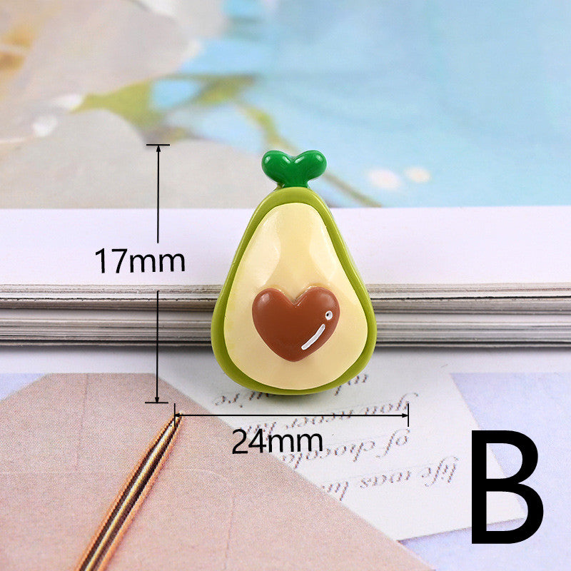 One glossy avocado-shaped resin cabochon: green outer, cream inner, brown heart pit, labeled 17mm x 24mm.